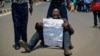 An opposition protester holds a placard denouncing electoral commission officials, at a demonstration in downtown Nairobi, Kenya, Sept. 26, 2017. 