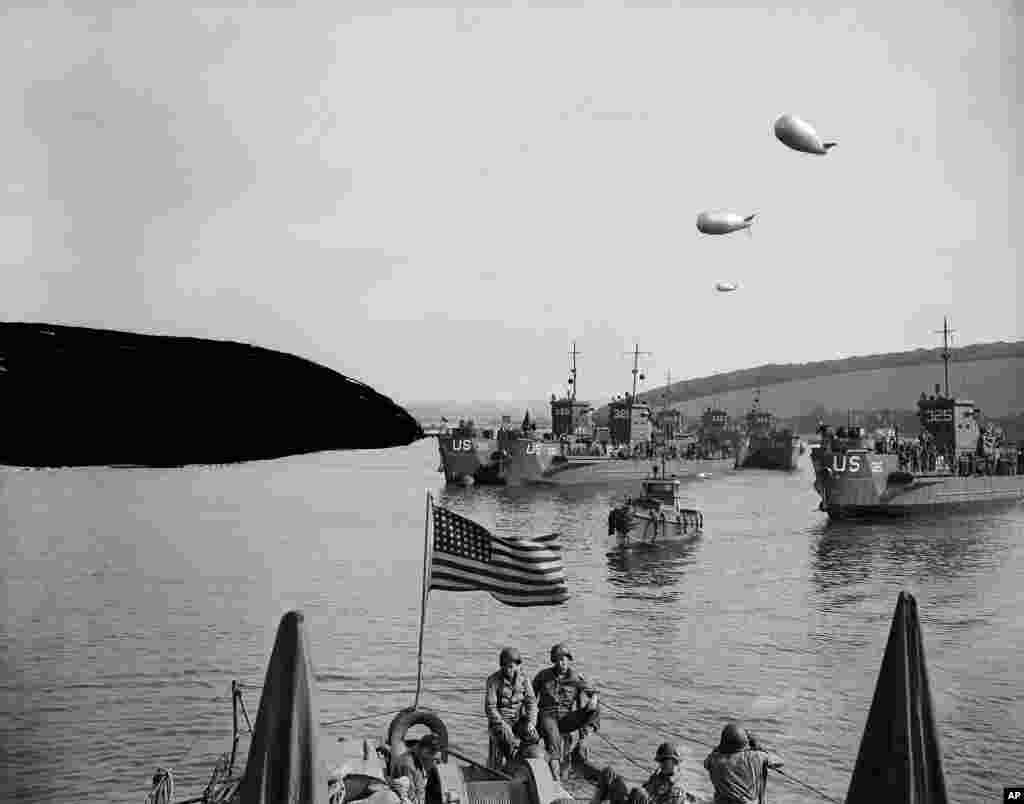 Landing craft loaded with American troops are guarded overhead by barrage balloons, Normandy, France, June 6, 1944.
