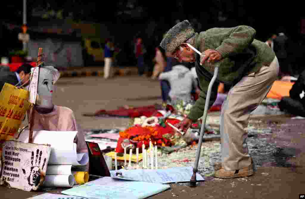 An elderly Indian man lights a candle at a makeshift memorial of a gang-rape victim in New Delhi, India, Janueary 3, 2013.