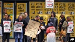 Jornalistas e manifestantes conversam com uma trabalhadora frente à sede do ANC