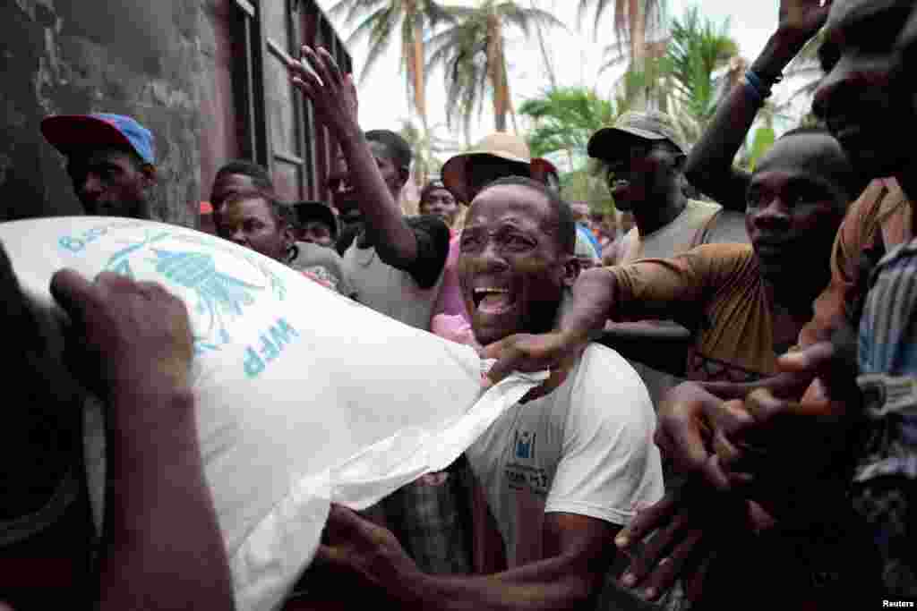 Para warga korban badai Matthew antri untuk menerima bantuan beras dari program pangan dunia PBB di kota Saint Jean du Sud, Haiti.