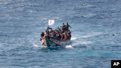 Migranti nagomilani na drvenom čamcu dok plove do luke u La Restingi na kanarskom ostrvu El Hierro, Španija, 18. avgusta 2024.