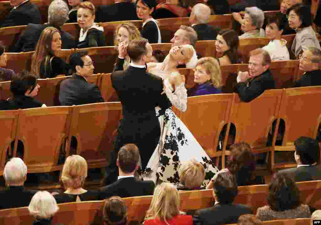 A couple dances in the "Golden Hall" as Israeli Argentine-born conductor Daniel Barenboim conducts the Vienna Philharmonic Orchestra during the New Year's Concert in Vienna.