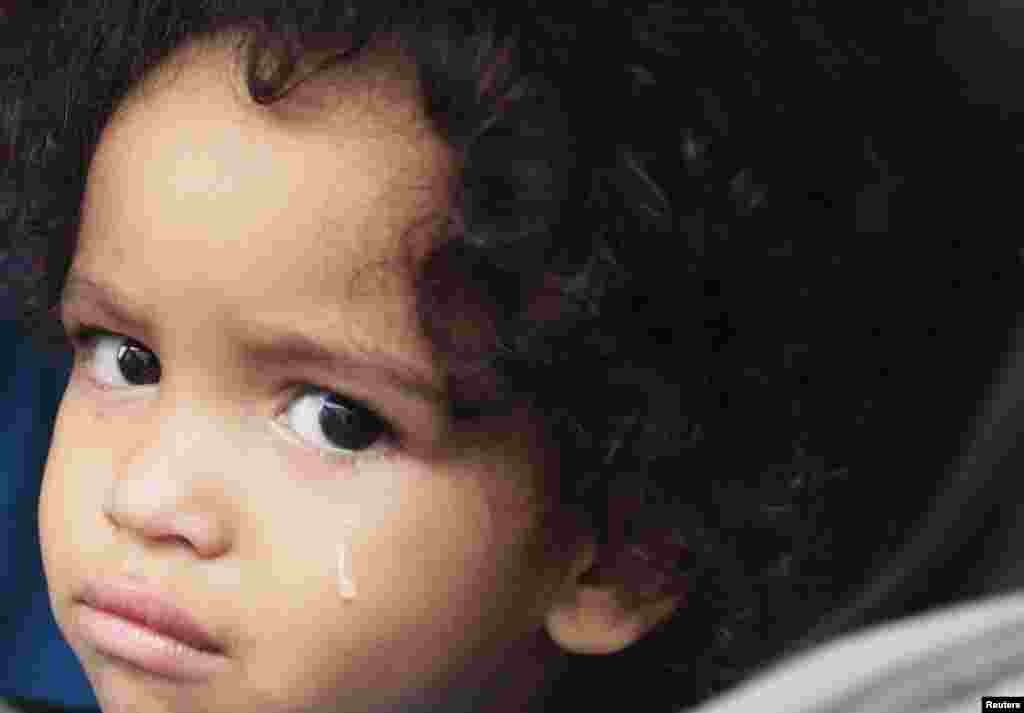 Jaden Fabian, 1, cries in her car seat as her family evacuates their home as Tropical Storm Isaac heads towards the Louisiana coast line, August 28, 2012.