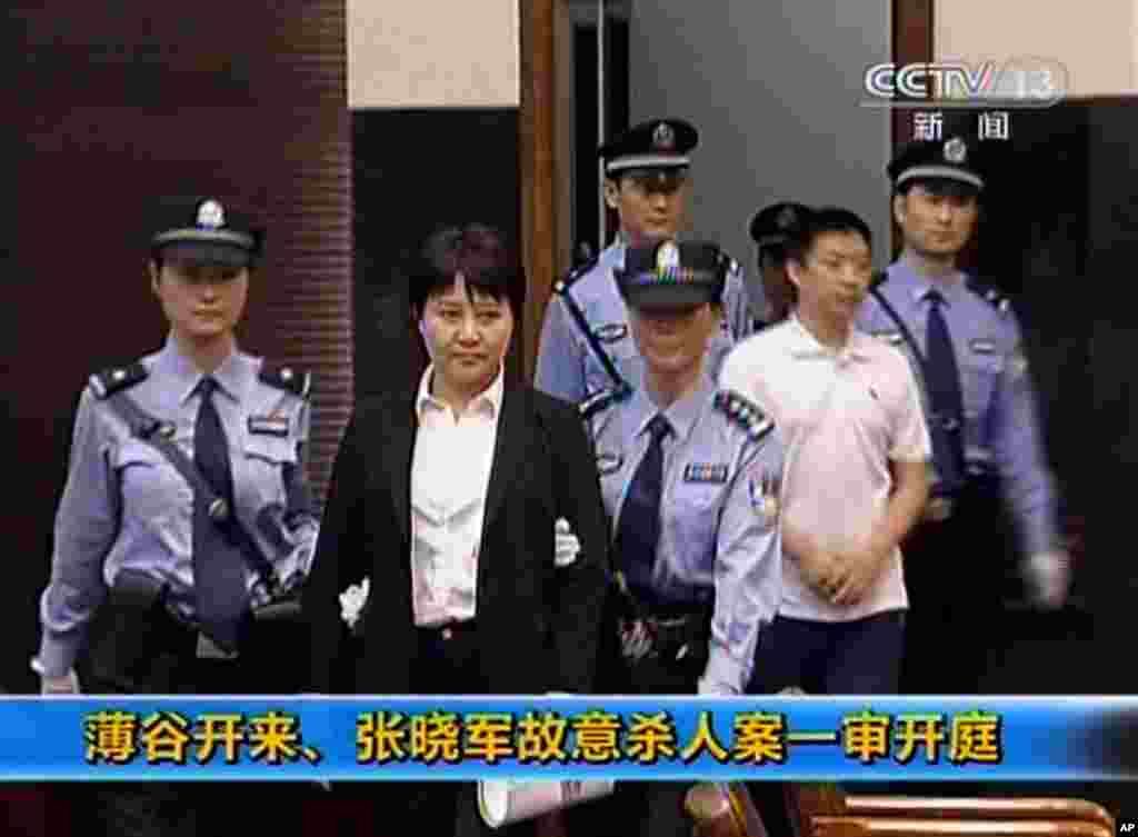 中央电视台播放的画面显示垮台的中国政治人物薄熙来的妻子谷开来和薄家勤务人员张晓军被带入中国东部的合肥市中级人民法院,他们被控害死了英国商人海伍德(2012年8月9日)。