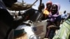 South Sudanese refugees collect aid food at a "Refugee Waiting Centre" in Al-Eligat area along the border in Sudan's White Nile state, Feb. 27, 2017.