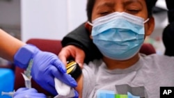Julian Salgado, 7, menerima suntikan kedua vaksin COVID-19 buatan Pfizer di Rumah Sakit Anak-anak Lurie di Chicago, pada 11 Desember 2021. (Foto: AP/Nam Y. Huh)