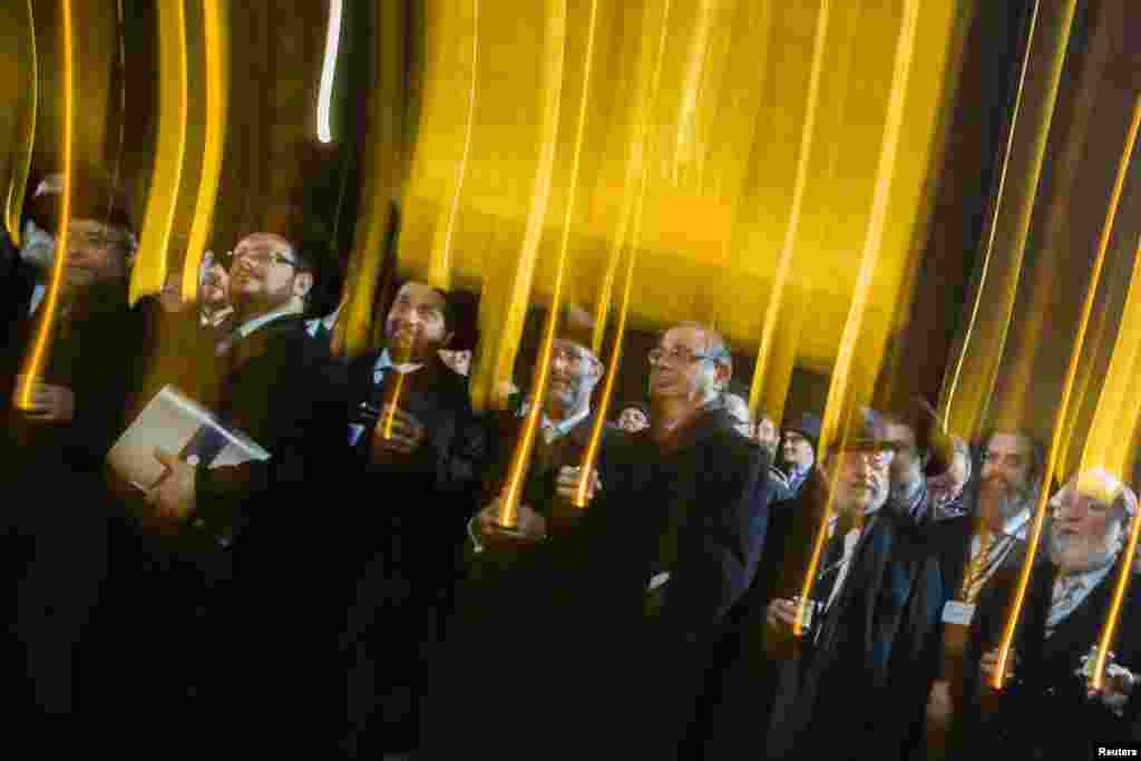 Peserta Konferensi Rabbi Eropa membawa lilin saat mereka memperingati ulang tahun ke-75 'Malam Kristal' atau malam di mana Nazi Jerman memulai operasi pencarian orang-orang Yahudi, di depan Gerbang Brandenburg di Berlin, Jerman.