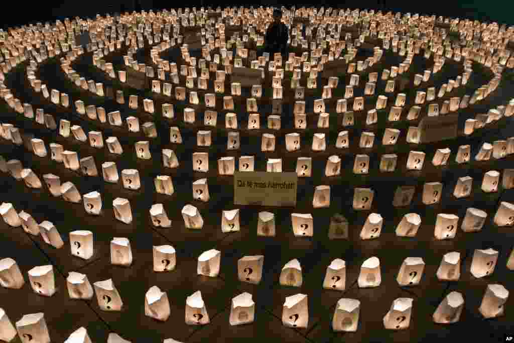 Seorang bocah laki-laki Kosovo duduk di tengah-tengah lingkaran lilin yang menyala untuk memperingati orang-orang yang hilang dalam perang Kosovo 1998-99 di Pristina, Kosovo.