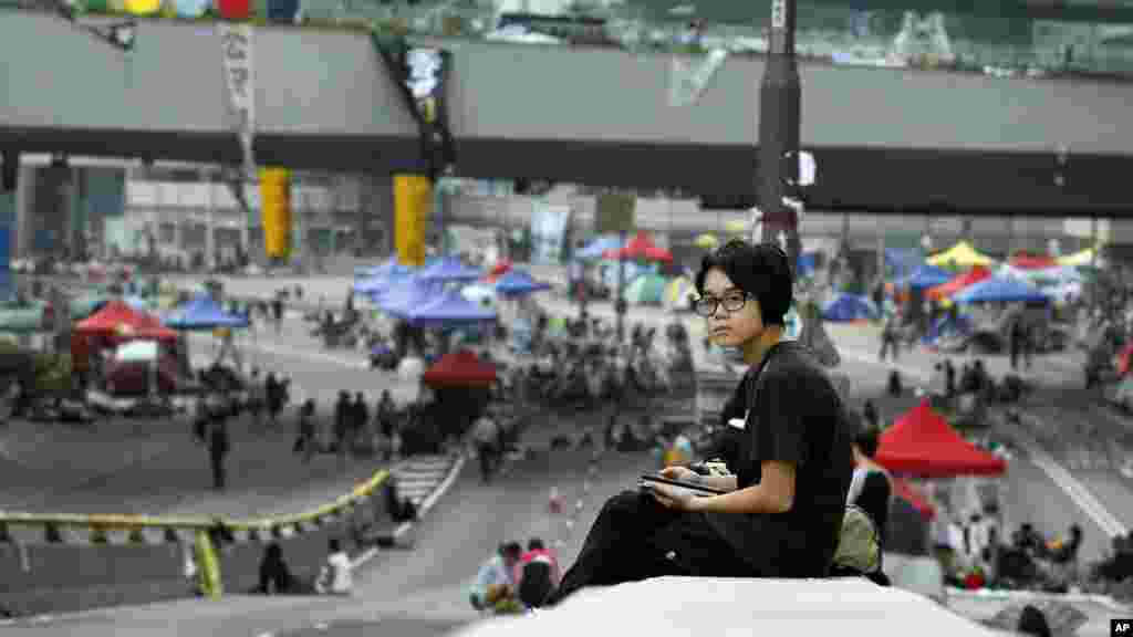 Seorang pelajar yang ikut berdemonstrasi bangun setelah tidur di jalan di Hong Kong (5/10). (AP/Wally Santana)