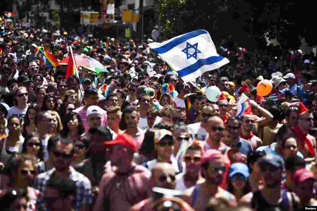 Orang-orang mengambil bagian dalam parade tahunan Gay Pride di Tel Aviv. Ribuan peserta berparade di jalan-jalan kota Israel yang bebas yang telah menjadi pusat wisata gay di Mediterania.