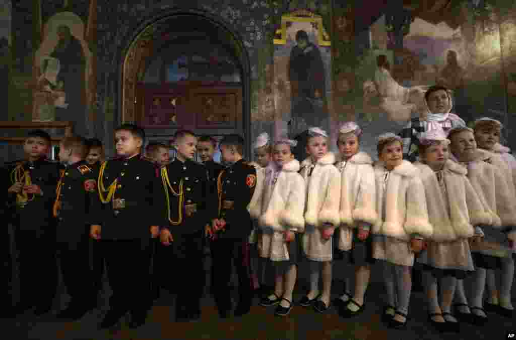 Anak-anak laki-laki dan perempuan berpakaian seragam kadet, menghadiri upacara pengambil sumpah di gereja Ortodoks di Kyiv, Ukraina.