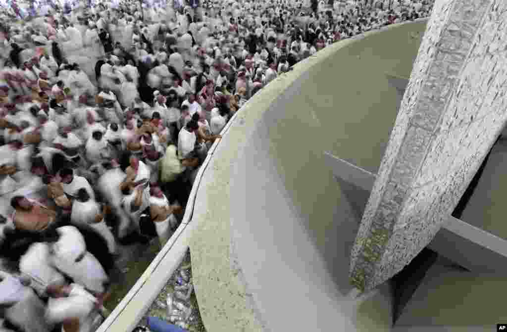 Muslim pilgrims cast stones at a pillar, symbolizing the stoning of Satan, in a ritual called "Jamarat," a rite of the annual Hajj, the Islamic faith's most holy pilgrimage, in Mina near the Saudi holy city of Mecca, Saudi Arabia, Friday, Oct. 26, 2012.