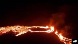 This photo provided by the Icelandic Met Office shows an eruption, center right, on the Reykjanes Peninsula in southwestern Iceland on March 19, 2021.