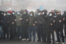 FILE - Demonstrators stand in front of a police line during a protest in Almaty, Kazakhstan, Jan. 5, 2022.