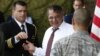 U.S. Secretary of Defense Leon Panetta, center, prepares to give a 'Challenge Coin' to U.S. military personnel stationed at Yokota Air Base in Yokota, Japan, Sept. 17, 2012.