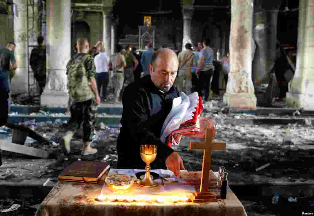 Seorang pria Kristen Irak menyiapkan misa pertama di gereja Grand Immaculate Church kota Qaraqosh, dekat Mosul, setelah kota ini dibebaskan dari cengkeraman ISIS.