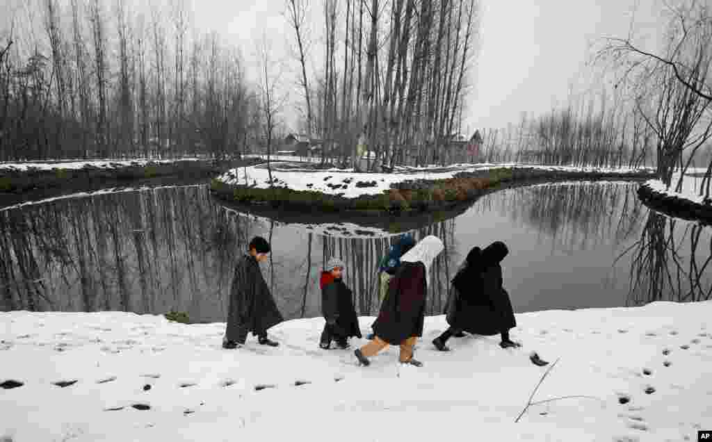 Kashmiri children walk on a snow-covered road on the outskirts of Srinagar, India.
