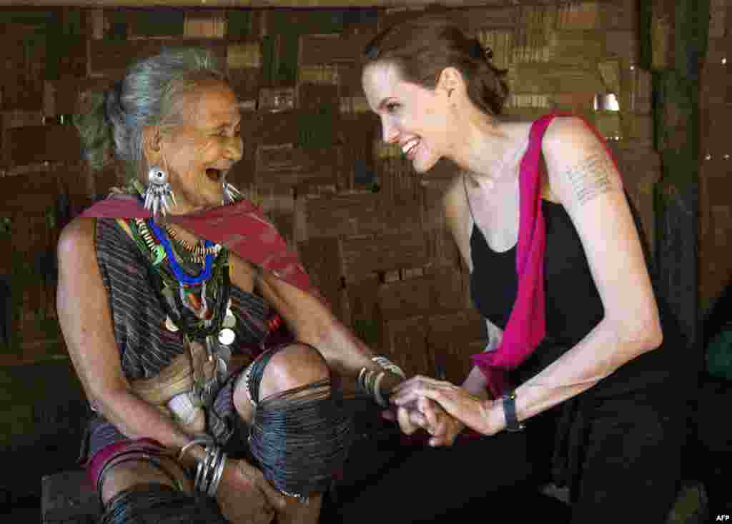 Utusan khusus Komisioner Tinggi PBB untuk Pengungsi (UNHCR) Angelina Jolie, bertemu dengan pengungsi dari etnis Karenni, Baw Baw Meh yang berumur 75 tahun dan keluarganya dari Myanmar di kamp pengungsi Ban Mai Nai Soi dekat perbatasan dengan Thailand. (UNHCR/AFP/Roger Arnold) 