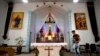 FILE - A parishioner walks past the altar as members of Lower Dafei Catholic Church hold an impromptu prayer vigil as they wait for Chinese officials to arrive and cut down their church's cross in Lower Dafei Village near Wenzhou in eastern China's Zhejia