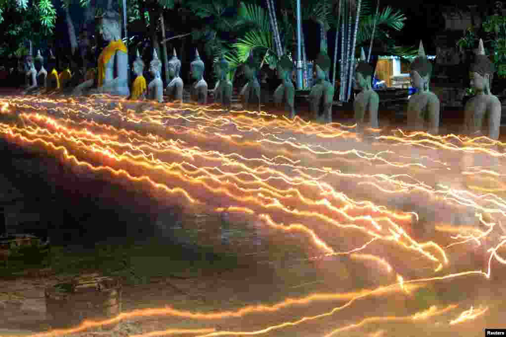 Ummat Budha membawa lilin saat melakukan ibadah di Hari Raya Waisak, perayaan kelahiran Buddha, di kuil Wat Yai Chai Mongkhon di Ayutthaya, Thailand.