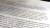 FILE - A section of the report from the U.S. intelligence community whistleblower to the U.S. House Intelligence Committee is seen after being released by the committee in Washington, Sept. 26, 2019.