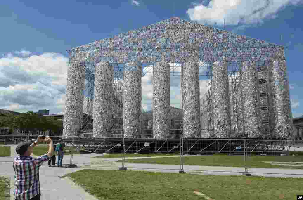 A man takes a photo of the art work 'The Parthenon of Books' by Argentine's artist Marta Minujin, which is under construction, in preparation for the upcoming art exhibition in Kassel, Germany.