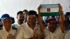 El candidato opositor a gobernador del estado Barinas, Sergio Garrido (R) celebra sosteniendo una bandera del estado Barinas junto al excandidato Freddy Superlano (C), durante una conferencia de prensa sobre la elección de gobernador en la ciudad de Barinas, Venezuela , el 9 de enero de 2022.