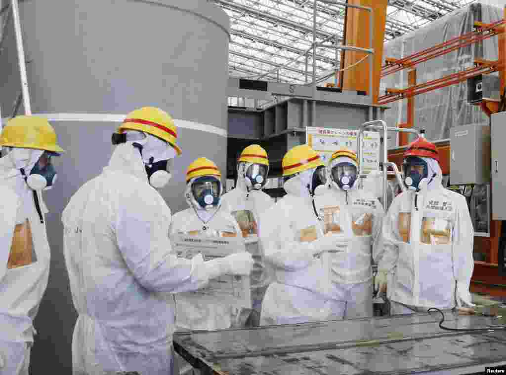 Japan&#39;s Prime Minister Shinzo Abe (R) is briefed about water treatment equipment during his inspection tour of the tsunami-crippled Fukushima Daiichi nuclear power plant, Sept. 19, 2013.