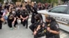 USA, Maryland, Bethesda, protestors and police kneeling together during the protest because of the George Floyd's death
