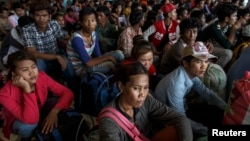 Cambodian workers wait for their documents to be processed at the Aranyaprathet police station as they prepare to move back to Cambodia in Sa Kaew June 15, 2014. Due to shortage of employment back home, many Cambodian workers try to find jobs overseas.