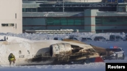 在多倫多皮爾森國際機場，急救人員在飛機翻倒事故現場工作。 (2025年2月17日)
