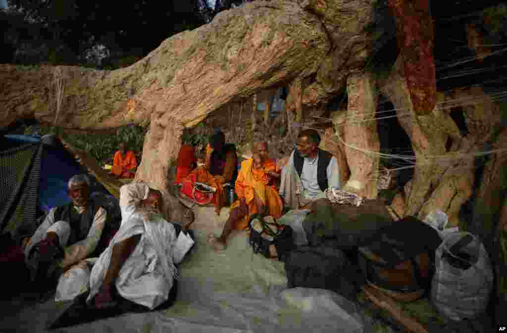 Penganut Hindu beristirahat di bawah akar pohon raksasa dalam upacara keagamaan 'Kumbh Mela' di Allahabad, India (11/2).