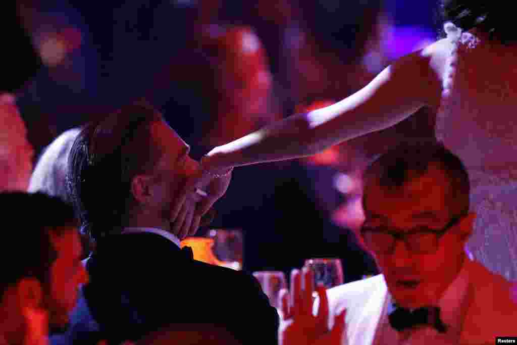 Aktris Prancis Marion Cotillard menyentuh pipi aktor Amerika Leonardo Di Caprio dalam sebuah acara lelang amfAR's Cinema Against AIDS 2014 di Antibes pada acara Festival Film Cannes ke- 67 di Prancis, 22 Mei 2014.