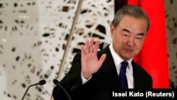 Menteri Luar Negeri China Wang Yi melambaikan tangan kepada para awak media seusai melaksanakan konferensi pers di Tokyo, Jepang, pada 24 November 2020. (Foto: Reuters/Issei Kato/Pool)
