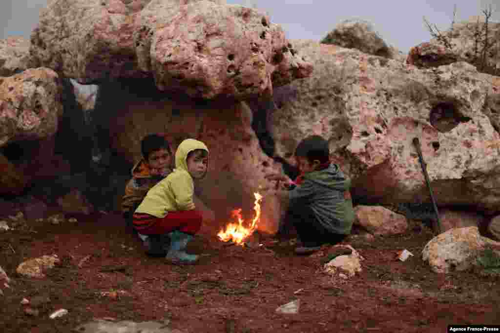 Children gather in front of a camp fire, in the Bardaqli camp for displaced people in the town of Dana in Syria's northwestern Idlib province, Nov. 20, 2021, as winter approaches on the International Day of Children's Rights.