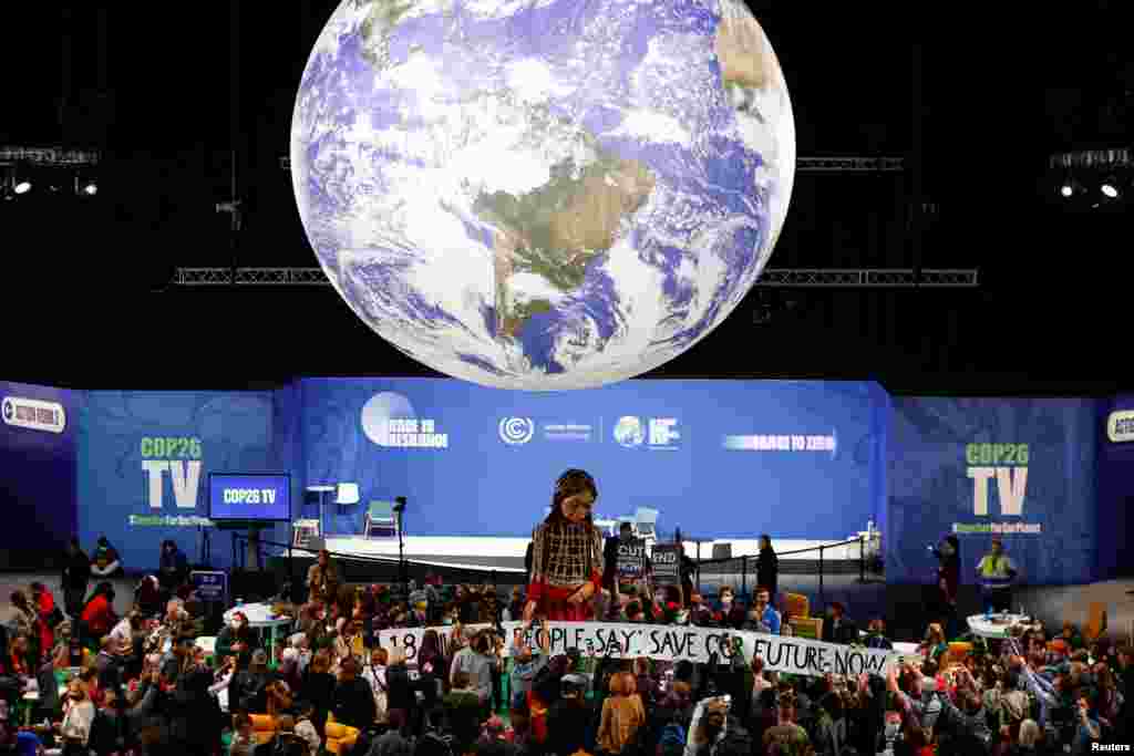 People gather around "Little Amal", a 3.5meter-tall puppet depicting a young Syrian refugee girl, is seen at the U.N. Climate Change Conference (COP26) in Glasgow, Scotland.