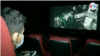 Un venezolano ve una pantalla en un complejo de cine en Caraca, en octubre de 2021. [Foto: VOA - captura de pantalla]