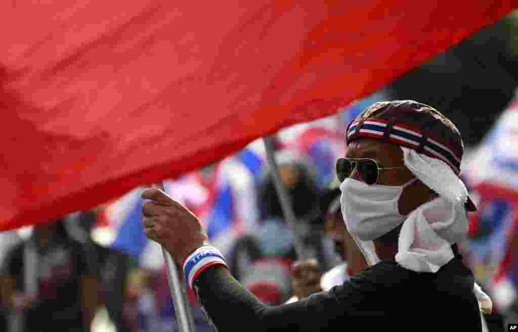 An anti-government protester waves a national flag during a rally in Bangkok, Feb. 7, 2014.