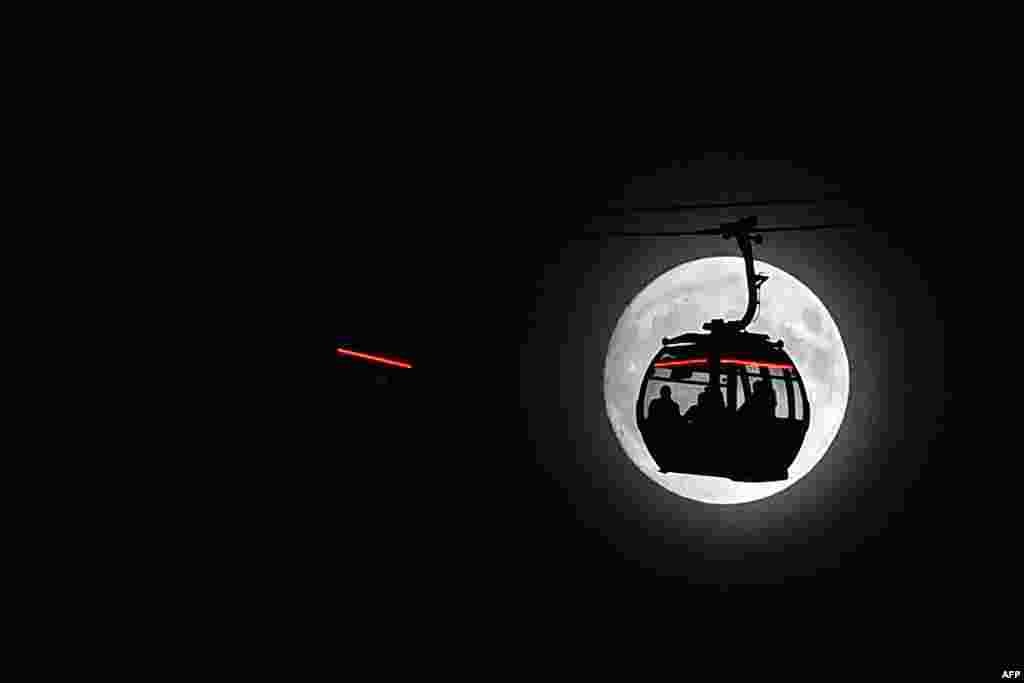 Bulan purnama &quot;supermoon&quot; terlihat di belakang kereta gantung di London, Inggris.