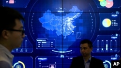 资料照：北京举行的全球移动互联网大会的参观者站在一个显示中国地图的电子信息显示屏前。（2018年4月26日）