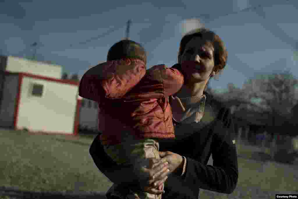 Syrian mother waiting to be fingerprinted in the closed container and tent camp in Harmanli. UNHCR/D.Kashavelov