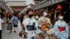 身穿和服戴着口罩的日本少女走在东京购物街上。（2021年8月13日）