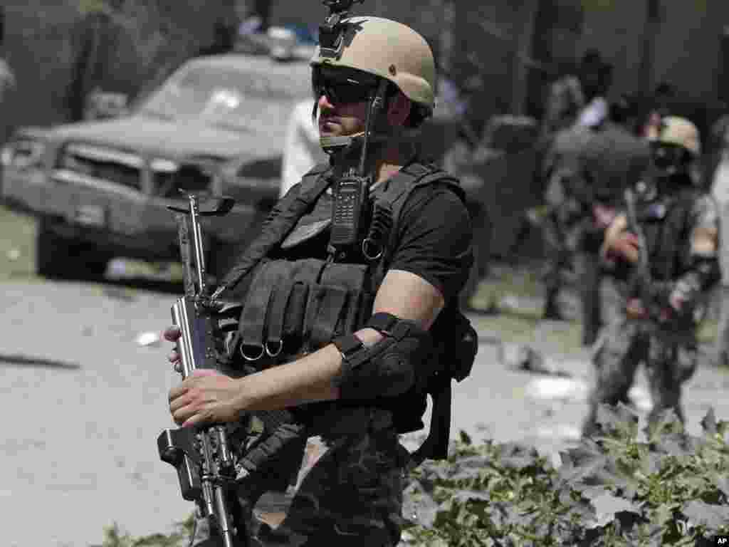 Afghan security forces stand guard at the site of a blast in Kabul, June, 18, 2013.