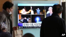 人们在首尔火车站观看有关朝鲜发射导弹的电视新闻。（2017年11月30日）