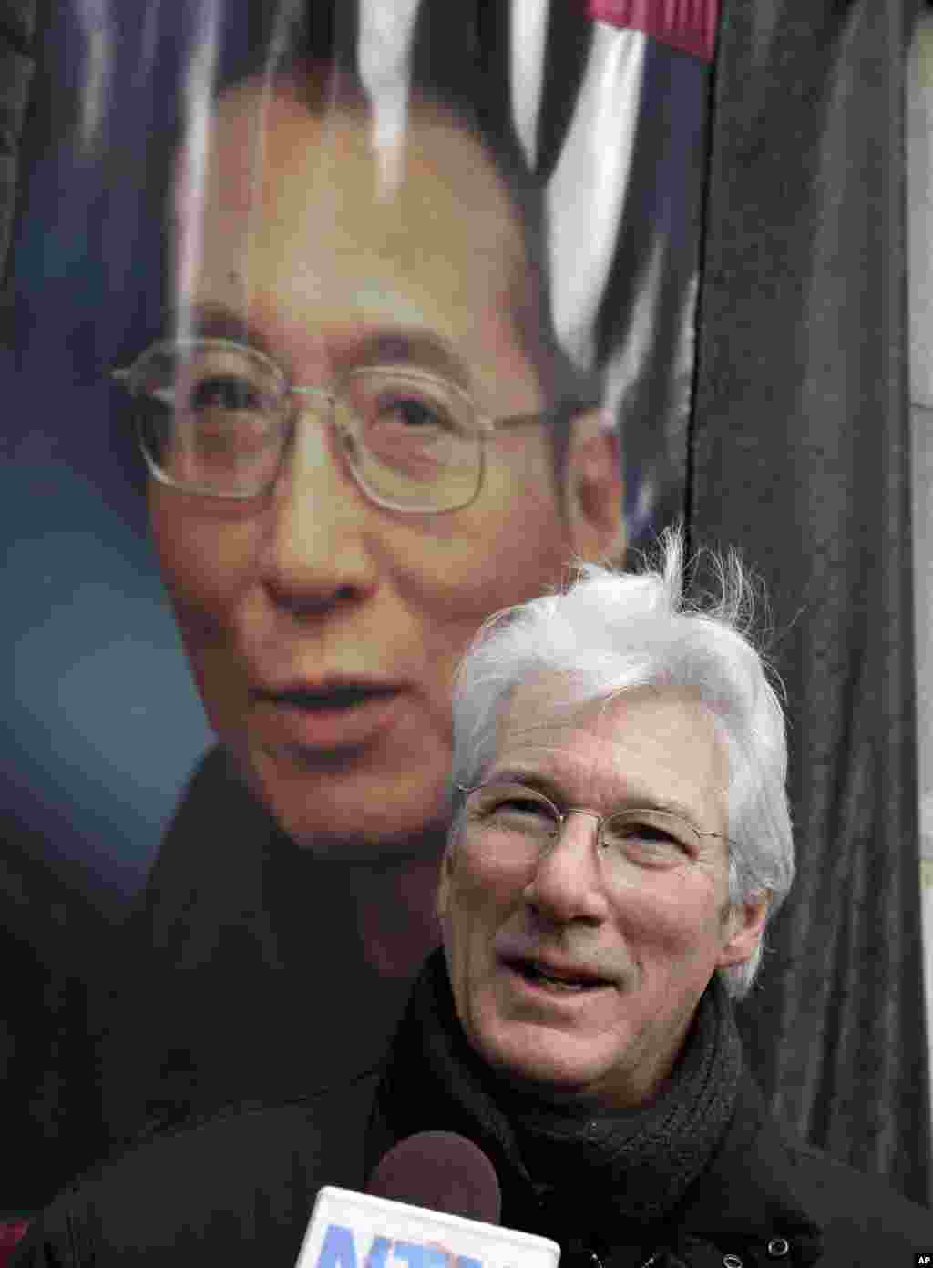 在纽约联合国总部对面的集会中,在刘晓波的照片前面,美国著名演员理查德·吉尔接受采访(2012年12月10日)