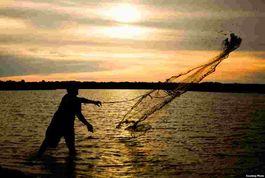 Jose Coelho dari Brazil mendapat juara harapan dengan foto berjudul "Fisherman in the Amazon".
