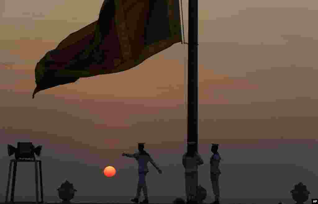 Navy sailors lower the Sri Lankan national flag as the sun sets on New Year's Eve in Colombo, Sri Lanka.