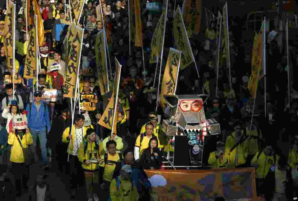 Protesters carry an effigy of a wolf representing Hong Kong's Chief Executive Leung Chun-ying march during a demonstration in Hong Kong, Jan. 1, 2014.