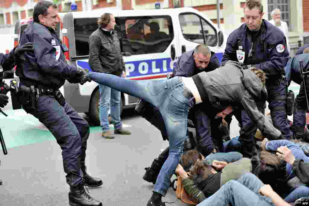 Polisi menyeret seorang pengunjuk rasa ketika terjadi demonstrasi seniman dan pekerja hiburan yang dikenal sebagai "intermittents du spectacle", di dekat wilayah Direktorat of Cultural Affairs (DRAC) di Lille, Perancis utara, untuk memprotes rencana pemerintah mereformasi status mereka. 